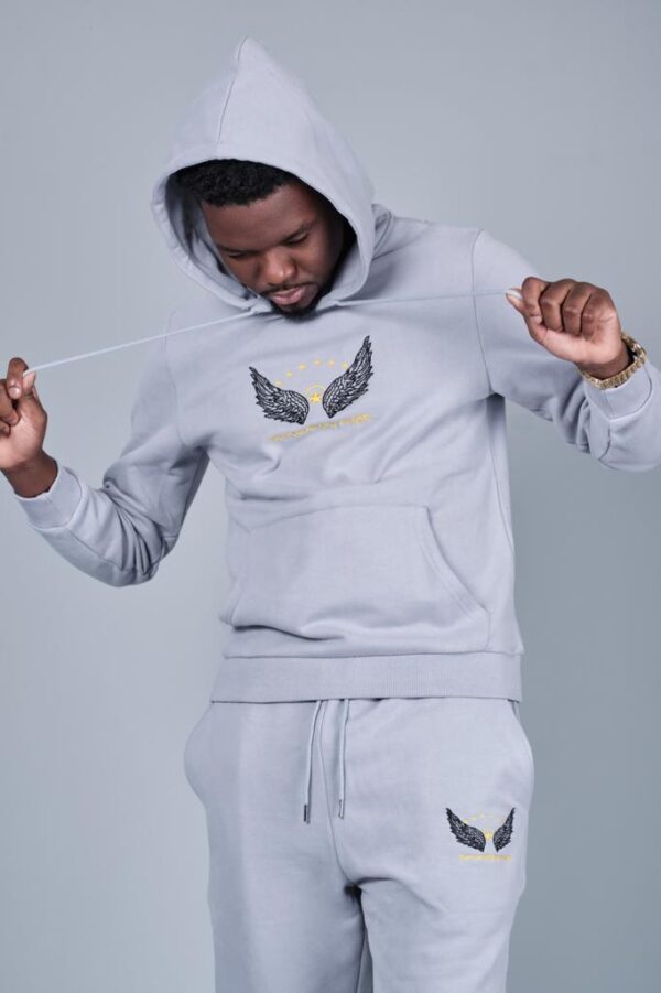 A man wearing an unisex affordable hoodie and tracksuit, very comfortable and soft, made of 75% cotton and 25% polyester with kangaroo pockets.