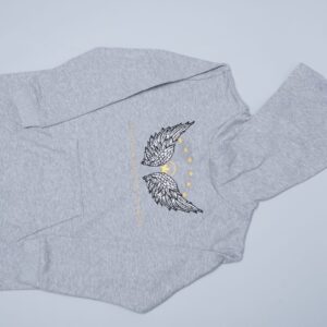 A 100% cotton unisex kids hoodie, size 3T (for a 3-year-old) and 7T (for a 7-year-old), with wings on it.